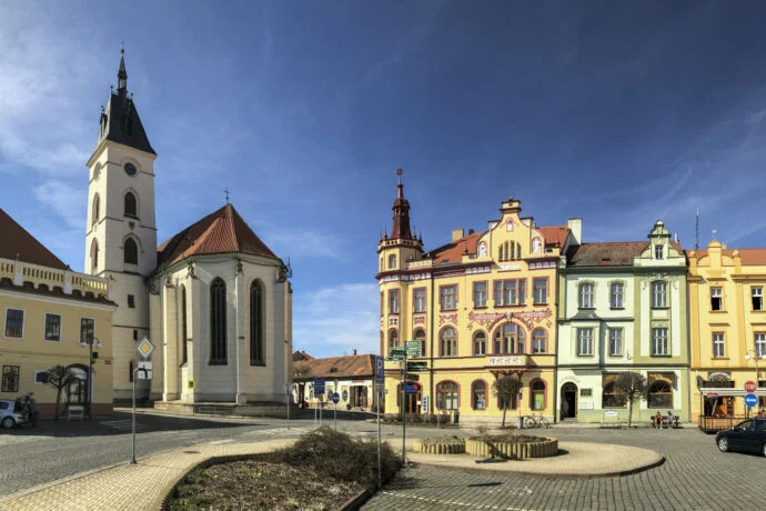 Historické náměstí s kostelem a barevnými domy v Prachaticích.