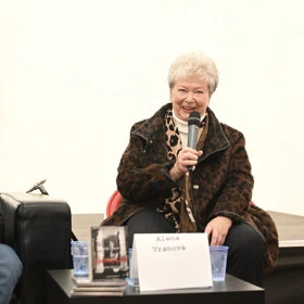 Herečka Alena Vránová při vystoupení s mikrofonem.