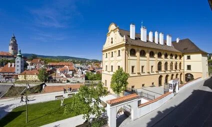 Historické budovy v Českém Krumlově s kostelem na pozadí.