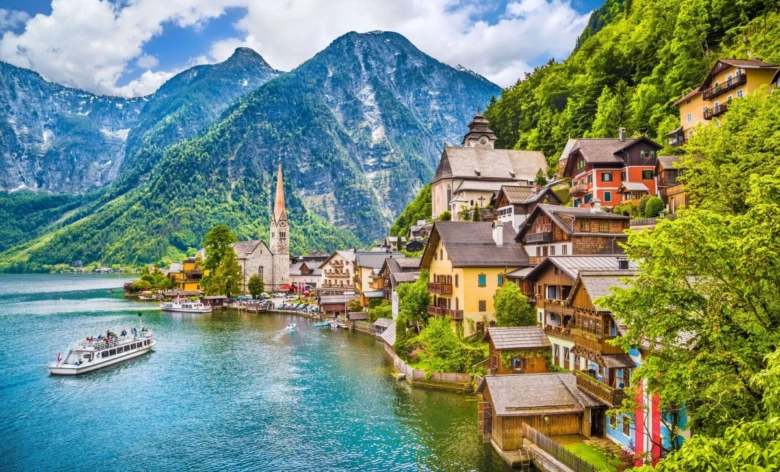 Pohled na vesnici Hallstatt u jezera s horami v pozadí.