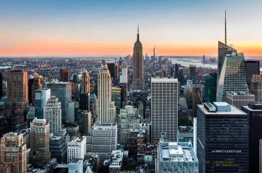 Panoramický pohled na newyorskou oblohu s mrakodrapy při západu slunce.