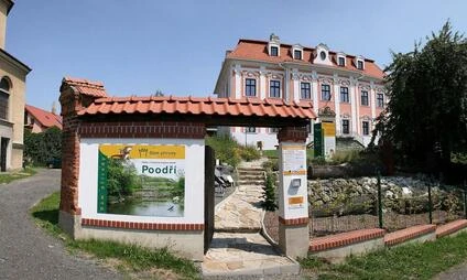 Vstupní brána do parku Poodří v Novém Jičíně s historickým domem.