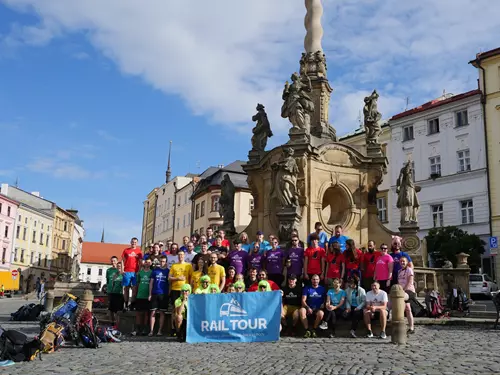 Skupina běžců s vlajkou na náměstí v Olomouci.