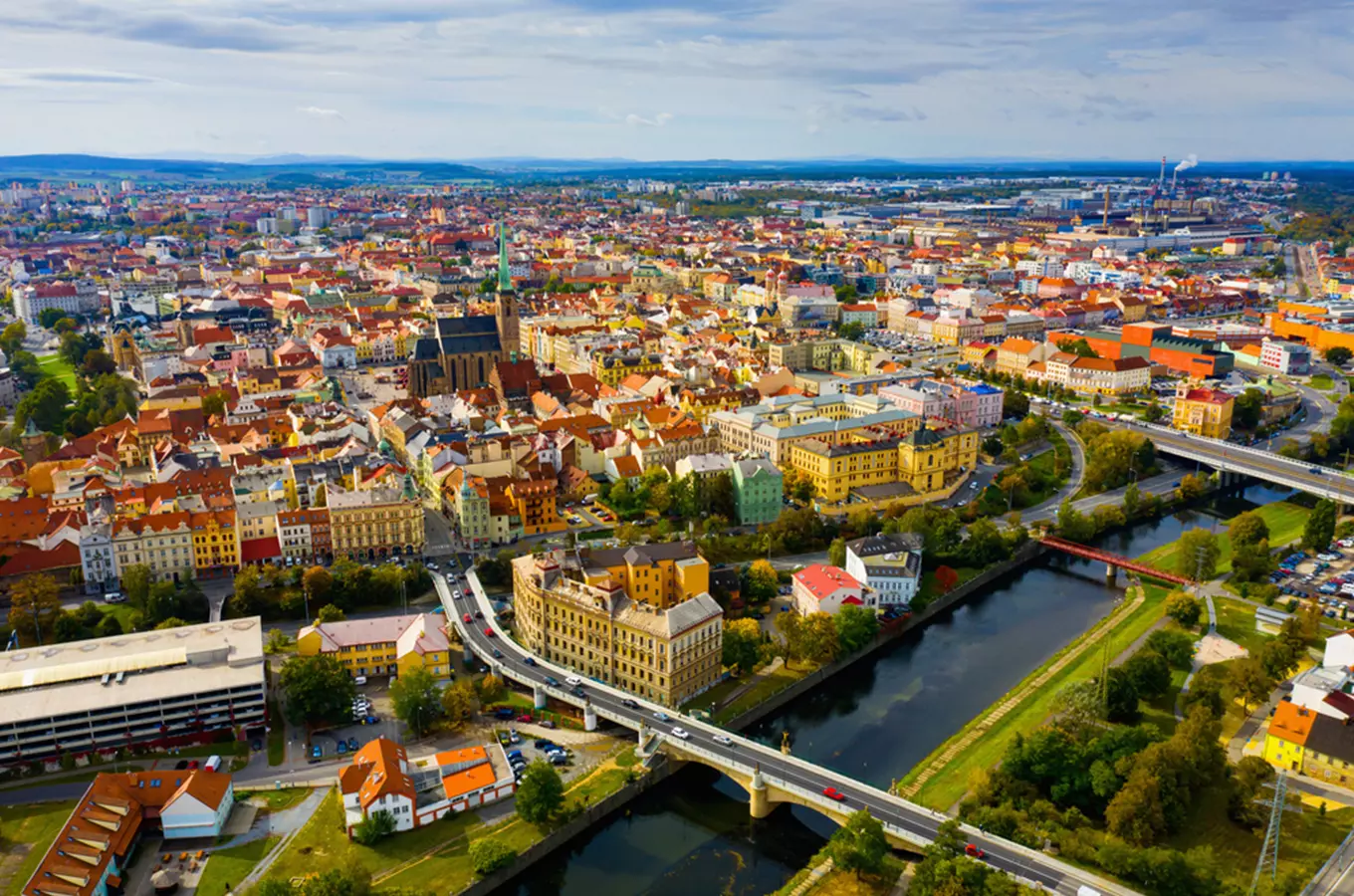 Pohled na historické centrum Plzně s řekou a mosty.