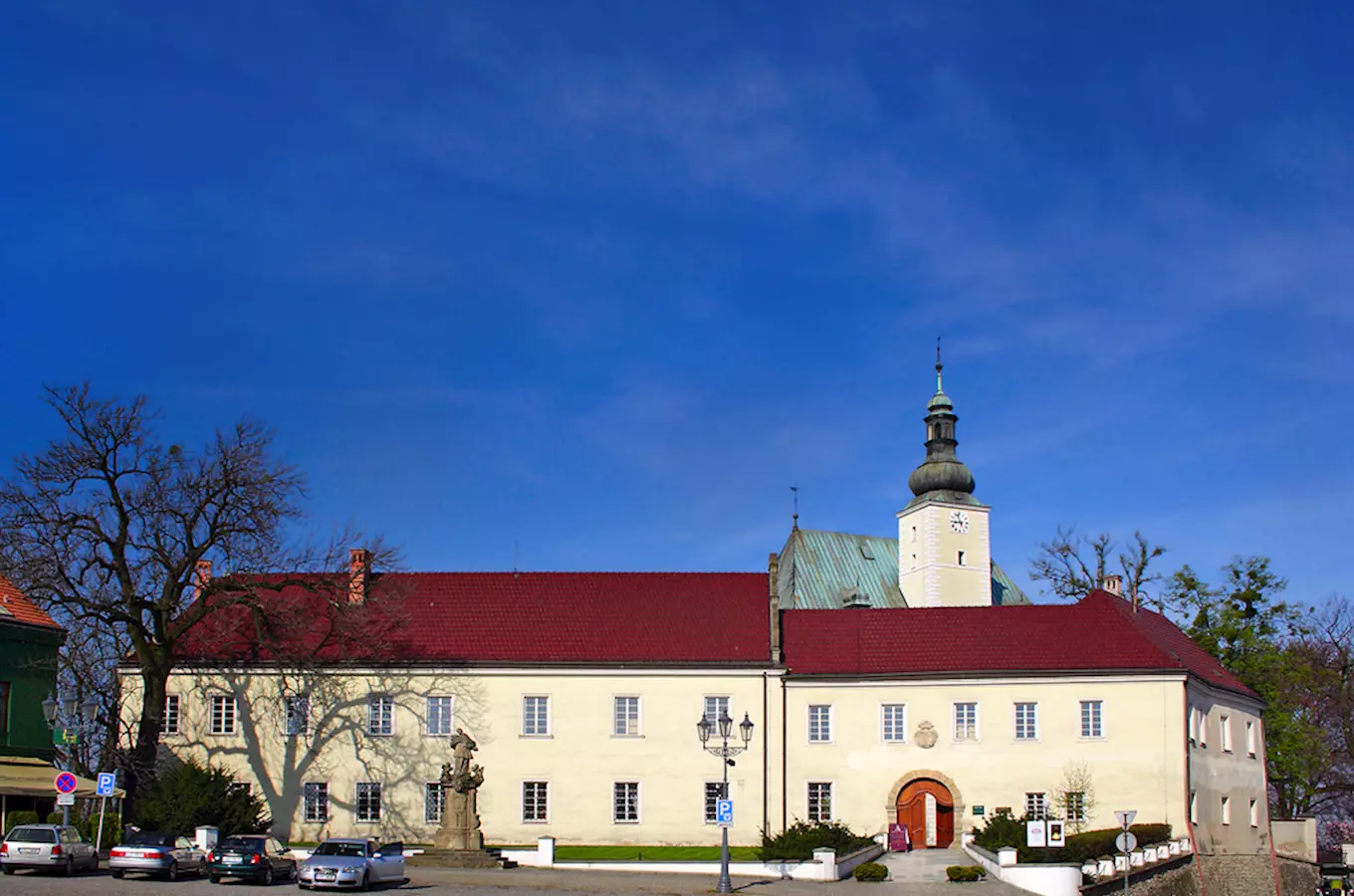 Historická budova s věží ve Frýdku-Místku pod modrou oblohou.