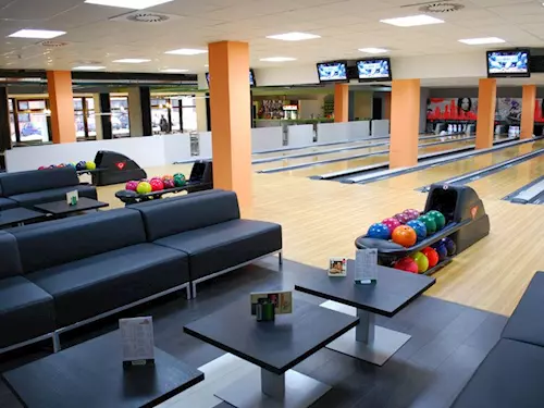 Vnitřek bowlinghaly v Praze s dráhami a sedacími místy.