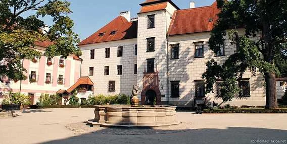 Historická budova s fontánou na nádvoří v jižních Čechách.