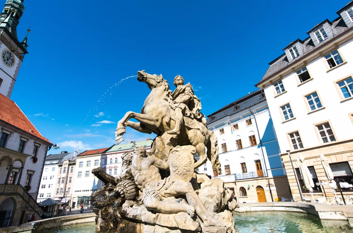 Socha s koněm v Olomouci na náměstí pod modrou oblohou.