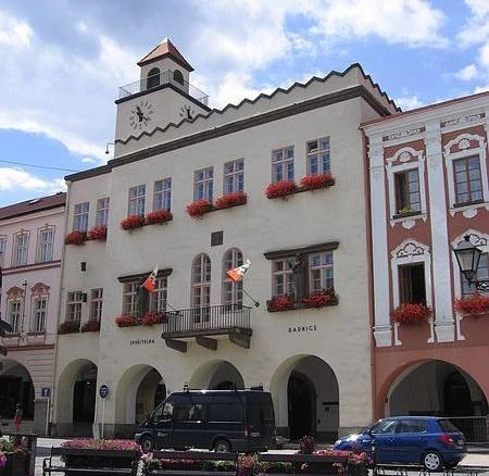 Historická budova radnice s květinovými boxy na oknech v Novém Jičíně.