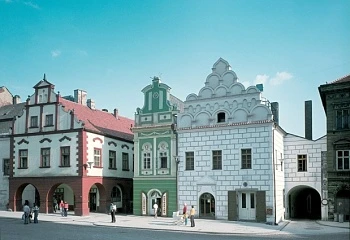 Historické budovy na náměstí v Tábore pod modrou oblohou.