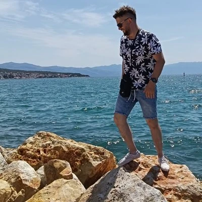 Muž stojí na skále u moře, vhodný pro úvodní obrázek.