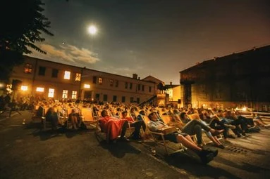 Venkovní kino v Praze za měsíční noci s diváky.