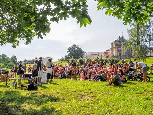 Venkovní kulturní akce s diváky před historickým zámkem v Hradci Králové.