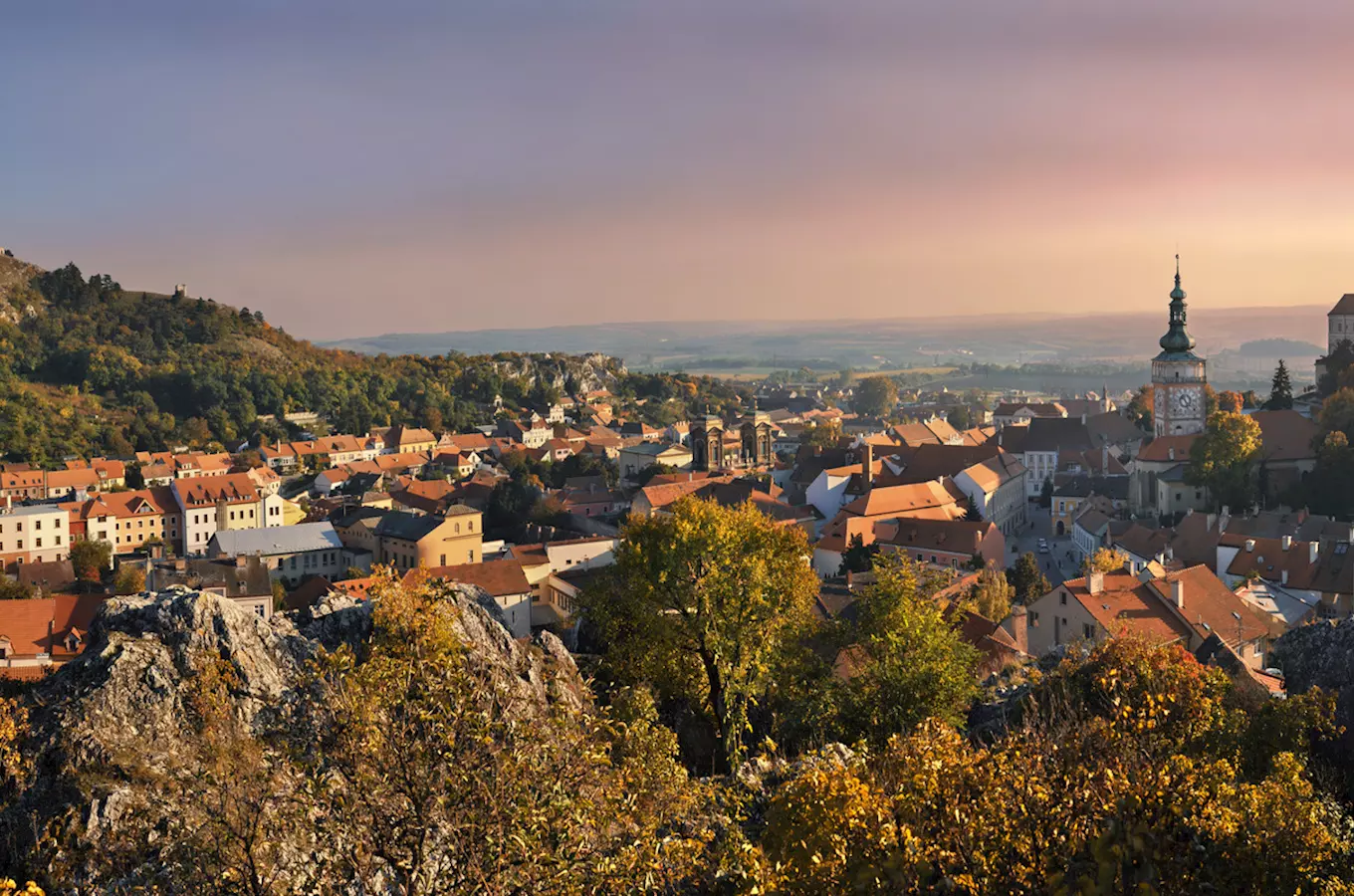 Pohled na městečko Mikulov s kostelem a hradem v podvečer.