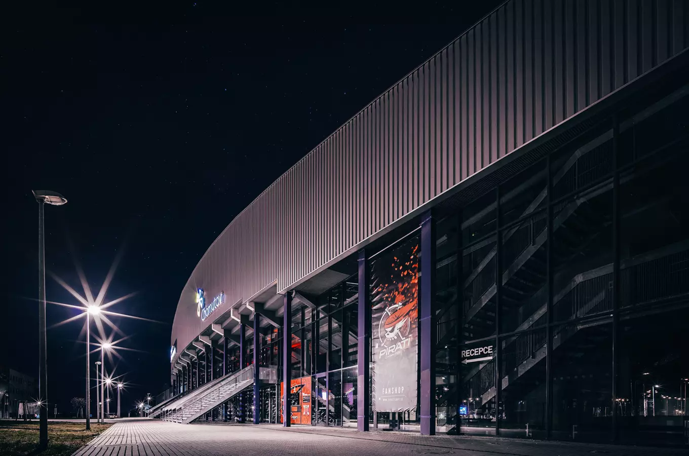 Noční pohled na stadion v Chomutově s osvětlením a logem Piráti.