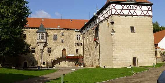 Historické hradní budovy v Roudnici nad Labem na pozadí zelené trávy.
