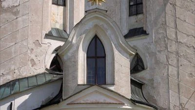 Detail kamenné věže s gotickým oknem na Klimentu v Praze.