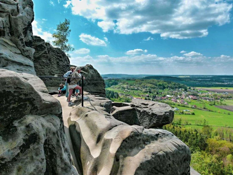 Turisté na skalním výhledu v Českém ráji s panoramatickým pohledem.