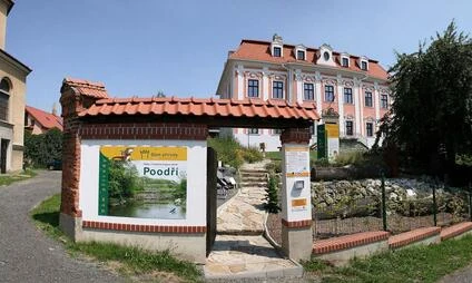 Vstupní brána s tabulí Poodří před historickým zámek v Kopřivnici.