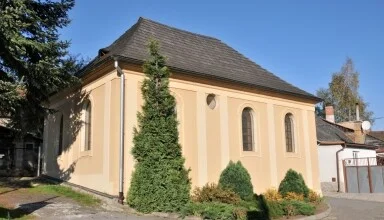 Malá žlutá kaple s tmavou střechou v Ledči nad Sázavou.