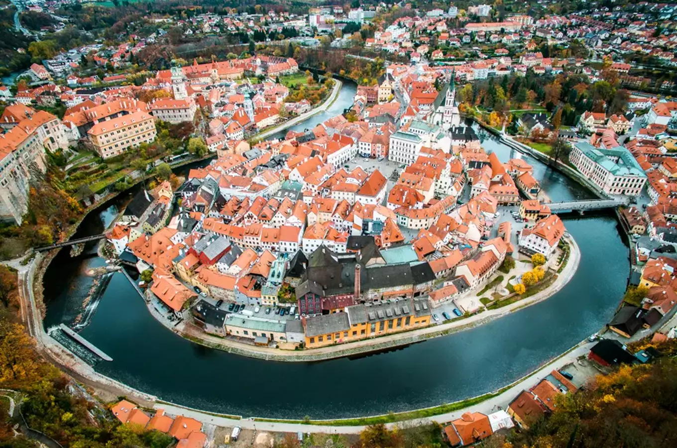 Pohled na historické město Česká Budějovice obklopené řekou.