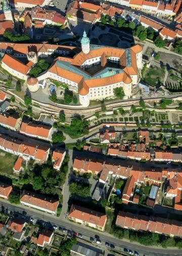 Vzdušný pohled na město Mikulov s hradem a červenými střechami.