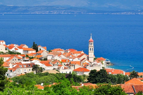 Historické město Trogir s červenými střechami u moře.