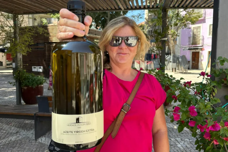 Žena drží velkou lahvičku portugalšského extra panenského olivového oleje venku.
