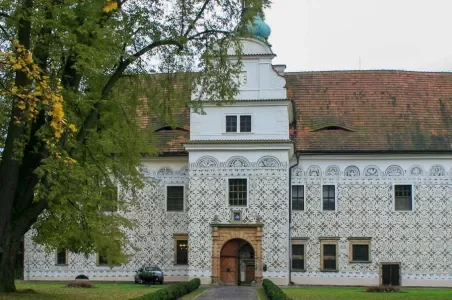 Historická budova s dekorativní dlažbou a obloukovým vchodem.