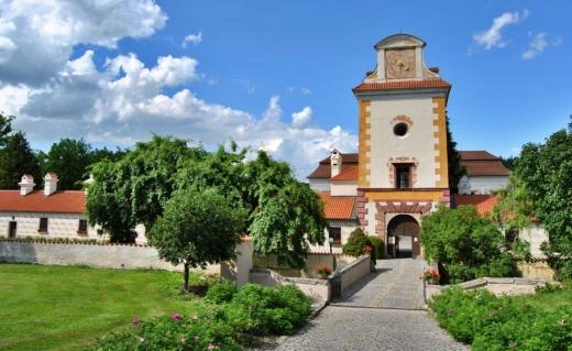 Vstupní brána zámku Kratochvíle v Netolicích s kamennou cestou.