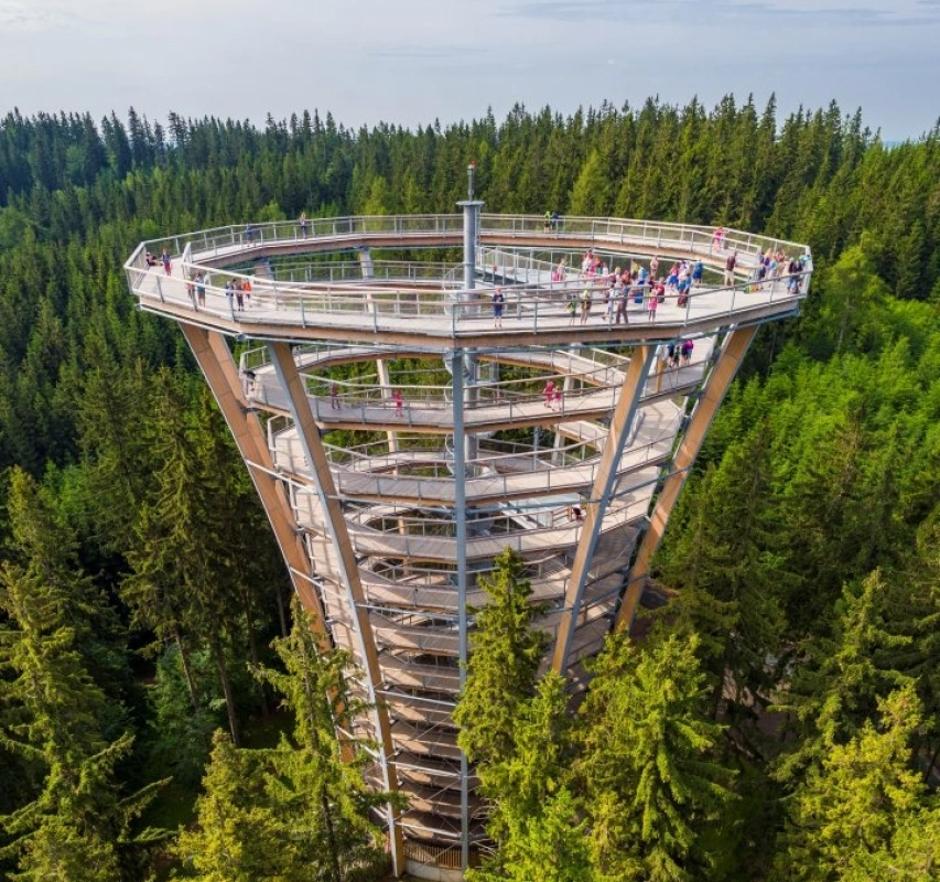 Moderní dřevěná rozhledna ve Špindlerově Mlýně uprostřed lesa.