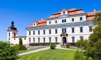 Historické zámek v Rychnově nad Kněžnou s věží na pozadí modrého nebe.