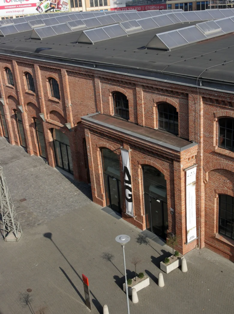 Historická cihlová budova v Brně s architektonickými detaily a solárními panely.