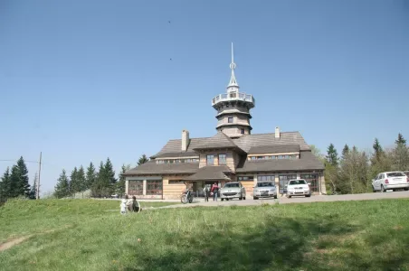 Věž na Novém Městě nad Metují s parkovanými auty.