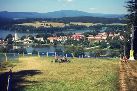 Pohled na město Lipno nad Vltavou s jezerem v pozadí.