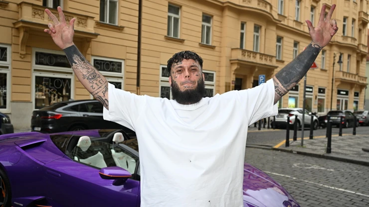 Jakub Enžl stojí s autem na ulici v Praze.