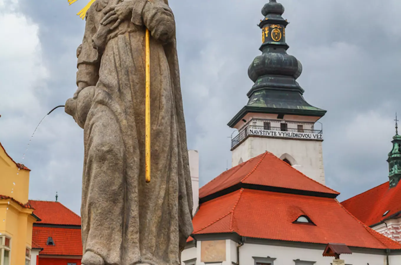 Socha svatého Jana Nepomuckého na náměstí v Pelhřimově s věží.
