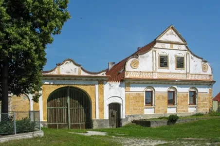 Historická brána v městečku Bechyně s žlutými zdmi.