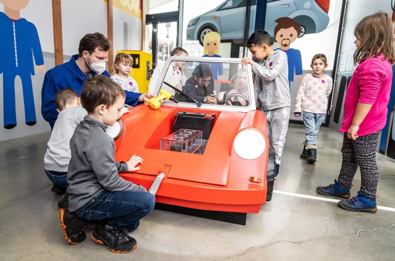 Děti hrají s interaktivní výstavní vozidlem v muzeu.