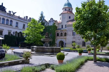 Historické nádvoří s fontánou a věží v Rychnově nad Kněžnou.