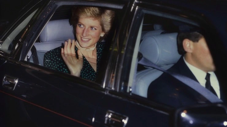 Princess Diana v autě usmívá se a mává davu.