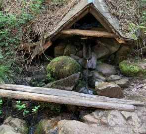 Dřevěná maštaľ s krytou studnicí v přírodě
