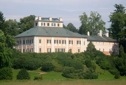 Exteriér zámku Opočno obklopený zelenou zahradou.