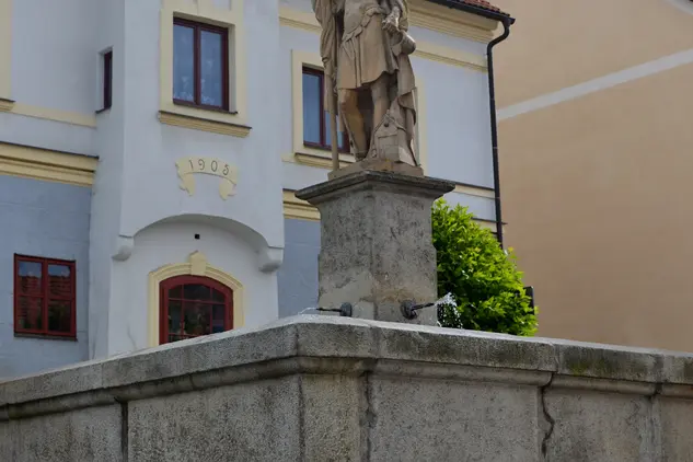 Socha na fontáně před historickým domem ve Vimperku.