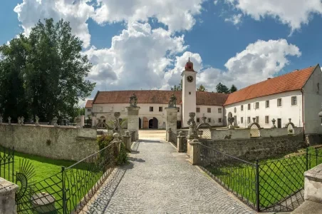 Dvůr hradu v Třebíči s kamennou bránou a kostelem.