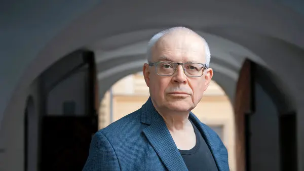 Portrét Miloše Zemana v modrém obleku s brýlemi.