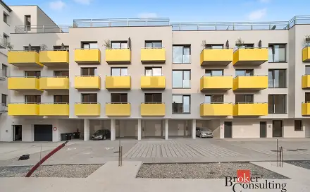 Moderní bytový dům s žlutými balkóny v Brně pro pronájem.