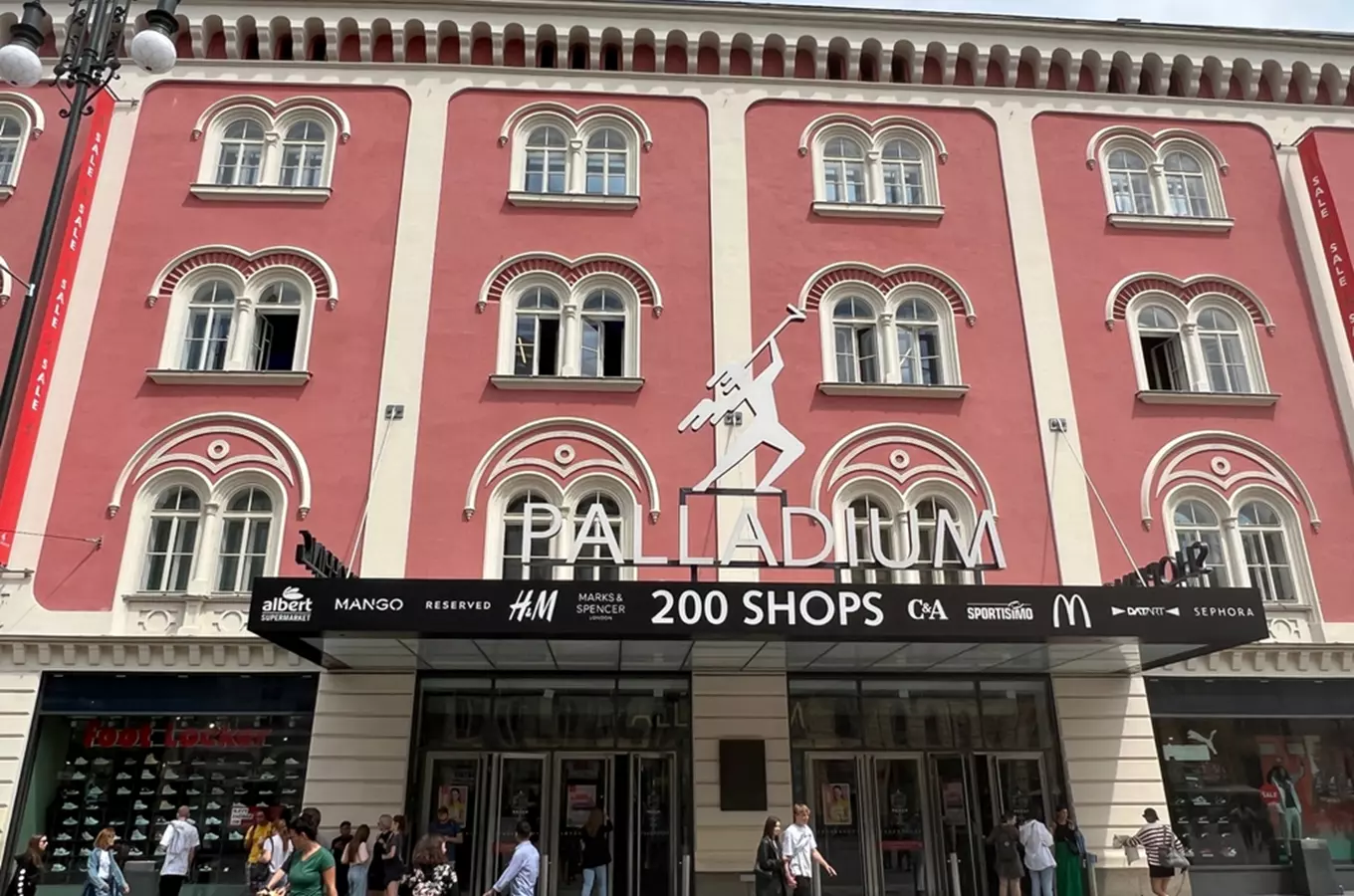 Fasáda nákupního centra Palladium v Praze s logy obchodů.
