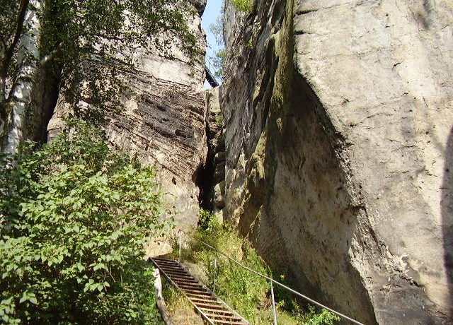 Hluboký skalní kaňon s dřevěnými schody pro turistiku.