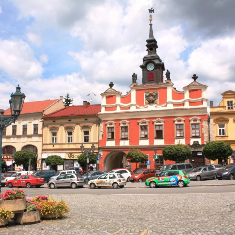 Historická budova na náměstí v Chrudimi s parkujícími auty.